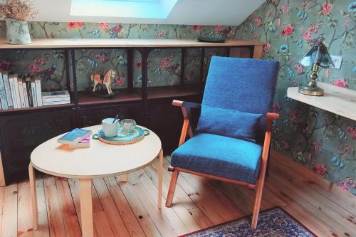 塔布La Maison de Sylvie, chambres d'hôtes à Tarbes的客房内的蓝色椅子和桌子