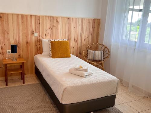 里戈尔Herdade da Vagem的一间卧室配有一张床,上面有两条毛巾