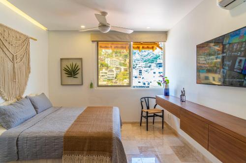 巴亚尔塔港Tres Marias Luxury Suites - Adults Only的一间卧室配有一张床、一张书桌和一个窗户。