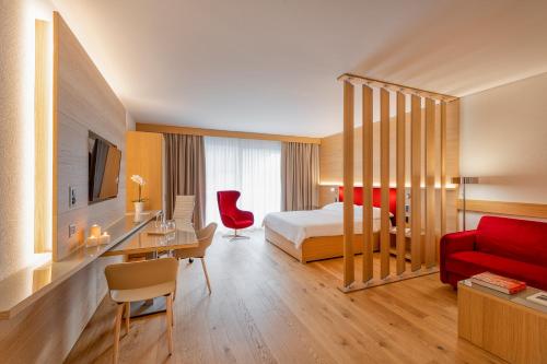 伯尔尼NEW OPENING 2022 - Los Lorentes Hotel Bern City的酒店客房,配有一张床和一张红色的沙发