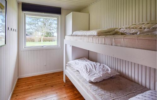 VemmenæsLiljebo的一间卧室设有两张双层床和一扇窗户。