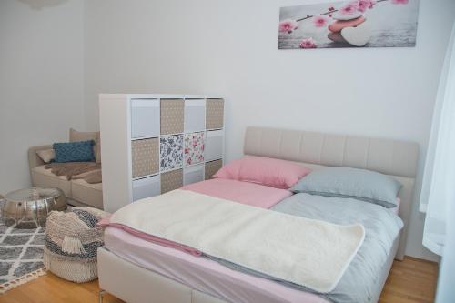 维也纳White Lotus Apartment的小卧室配有带粉色和蓝色枕头的床
