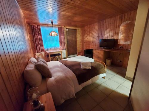 Le ChatelardLES TOURISTES的木制客房内的一间卧室,配有一张床