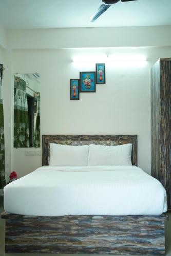 罗纳瓦拉Seva Holidays Villa Ac Luxury 4 BHK Villa with private swimming pool的卧室配有一张大白色床,墙上挂有图片