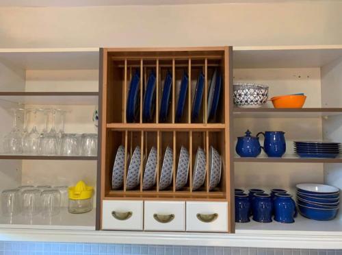 斯托诺韦Stornoway Holiday Let的装满蓝色花瓶和碗的橱柜