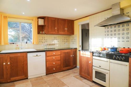 切尔滕纳姆The Snicket - Traditional Cotswold Home的厨房配有木制橱柜和白色家电