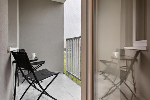 克拉科夫Republiki Korczakowskiej Apartamenty的客房设有带椅子和桌子的阳台。