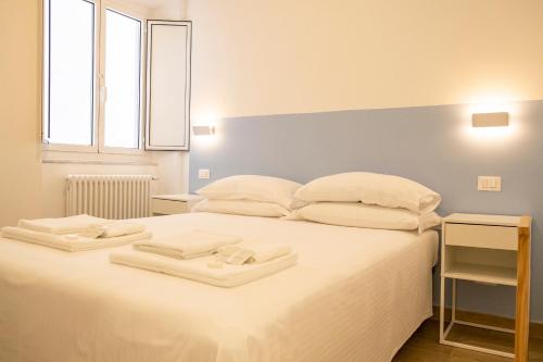 诺利Noliday Riviera Sea View Luxury Apartment的卧室配有白色的床和2条毛巾