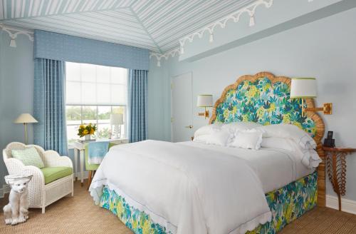 棕榈滩克罗尼酒店的卧室配有一张白色大床和一把椅子
