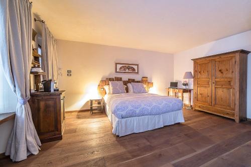 奥斯塔多莫斯蒂卡奥斯塔酒店的一间卧室配有一张床,铺有木地板