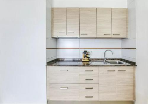 艾姆布里亚布拉瓦Apartamento vistas panorámicas的一个带木制橱柜和水槽的厨房