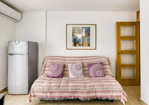 艾姆布里亚布拉瓦Apartamento vistas panorámicas的一间卧室配有一张带紫色枕头的床和一台冰箱