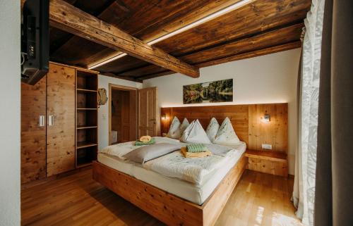 弗拉绍堡恩霍夫安特比契尔酒店的一间带一张大床的卧室,位于一个拥有木制天花板的房间