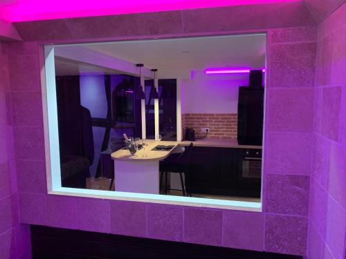 鲁昂Le Jacuzzi的紫色客房,设有带桌子的厨房