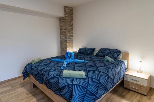 阿伊多夫什契纳Apartma Valič的一间卧室配有一张带蓝色棉被的床