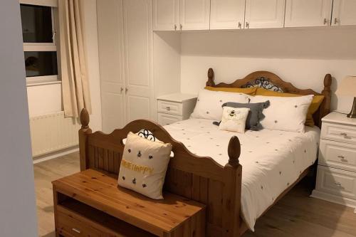 多尼戈尔Bumblebee Cottage的一间卧室配有一张带枕头和长凳的木床。