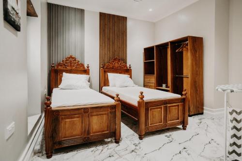 Stone TownNajma's villa的白色墙壁客房中的两张单人床