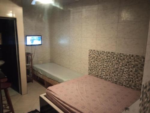 巴拉-沙希CASAS e KITNETS NOSSO CANTINHO的小房间设有床铺和电视
