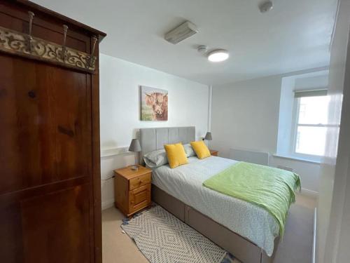 梅奥Westport town centre three bedroom的一间卧室配有一张带黄色枕头的床。