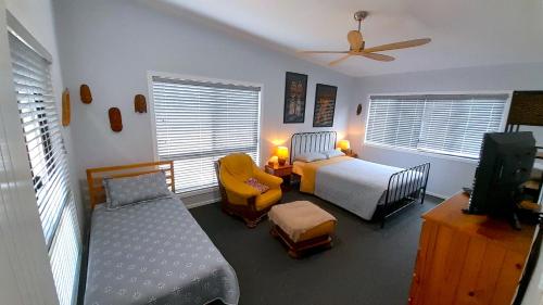 Apple Tree CreekCherry Mango Guesthouse的一间卧室配有一张床和一张床,并配有电视。