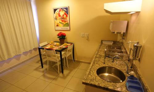 巴西利亚曼苏里2号公寓酒店的一个带水槽和桌子的小厨房