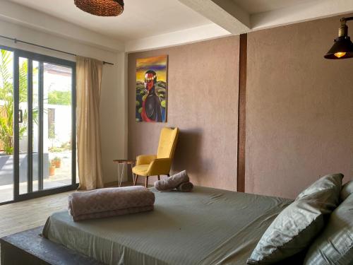 帕洛米诺Casa La Rayanna的一间卧室配有一张床和一张黄色椅子
