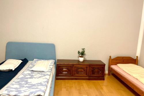 塞费塔尔Easy Home Apartment的一间设有两张床和一张植物桌子的房间
