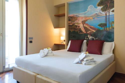 那不勒斯Hotel Suite Ares的卧室配有一张白色大床,墙上挂有绘画作品