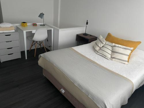 布宜诺斯艾利斯Montañeses 2830 Duplex Flat的一间卧室配有一张带桌子和椅子的床