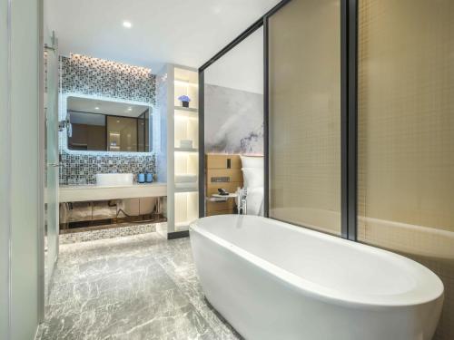 花都Novotel Guangzhou Baiyun Airport的浴室配有白色浴缸及水槽