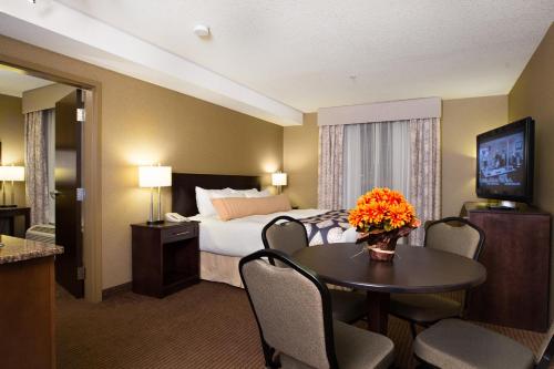 萨斯喀彻温堡萨斯喀彻温堡卡纳达酒店的酒店客房,配有床和鲜花桌