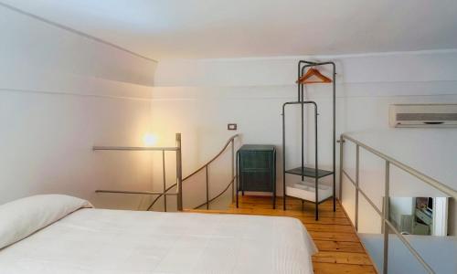加拉托内Cà Mì Apartment的一间白色的卧室,配有床和楼梯