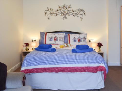 佩文西The Cabin的一间卧室配有一张带蓝色枕头的床。