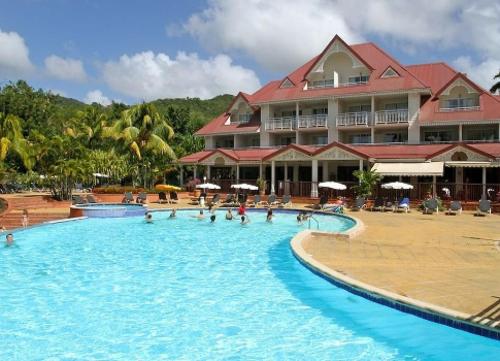 圣吕斯Studio Tropical avec vue mer dans une résidence hôtelière的一个带大型游泳池的度假村,里面的人