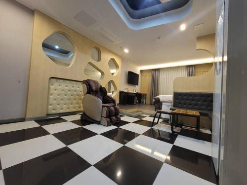 NamyangjuBigbell House的一间设有 ⁇ 形地板的客房和一间带椅子的房间
