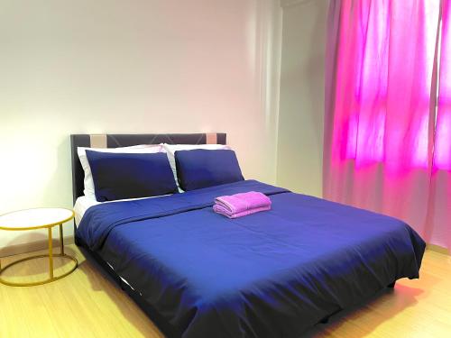 巴生Wallaway2stay Gravit8 Klang 2 Plus 1Room的一间卧室配有一张蓝色的床和粉红色枕头