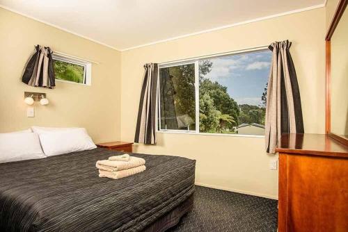 奥波蒂基Tasman Holiday Parks - Ohiwa的一间卧室设有一张床和一个大窗户