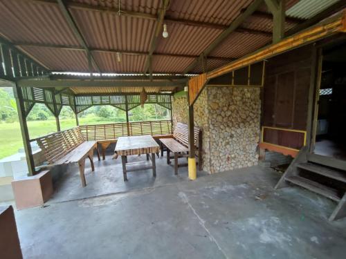 Kampong Ulu KalongPort Mancing Fishing Village的大楼内带长椅和桌子的庭院