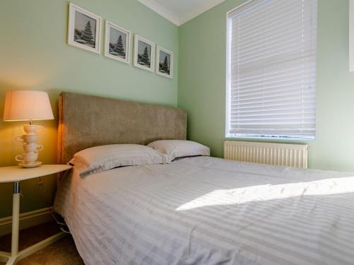 拉姆斯盖特Relax In Ramsgate的一间卧室配有一张床、一张桌子和一个窗户。