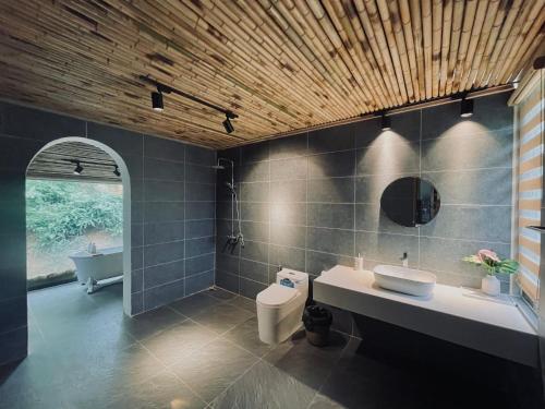 河内6Nature Bavi Retreat的浴室配有卫生间、盥洗盆和浴缸。