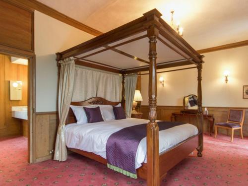 Hockwold cum WiltonHockwold Hall的一间位于酒店的卧室,配有一张天蓬床