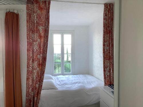 圣马克西姆Sainte Maxime Vue féerique piscine chauffée的卧室内的镜子,卧室配有床和窗户