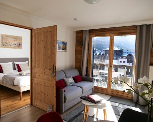 夏蒙尼-勃朗峰Mont Blanc 43, vue Mont Blanc , balcon, parking的带沙发和床的客厅以及窗户。
