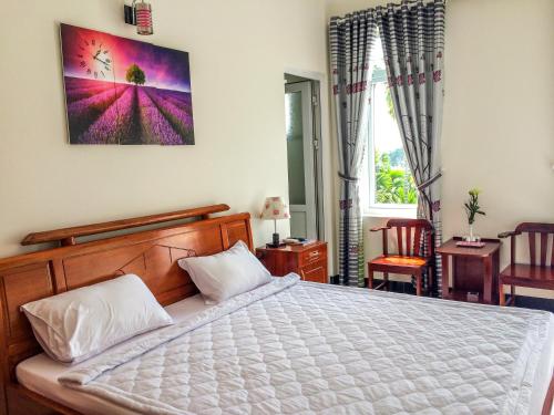 会安住宿加早餐服务民宿的一间卧室设有一张大床和一个窗户。