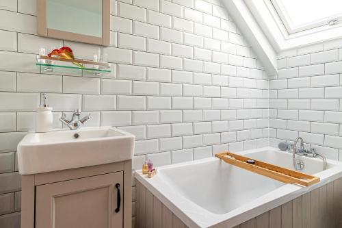 斯卡伯勒Garth Cottage in West Ayton的白色的浴室设有水槽和浴缸。