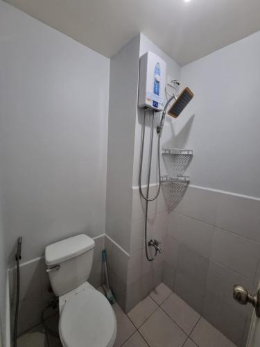 马尼拉Macks Awesome Place 204 NetflixFastWifi的白色的浴室设有卫生间和淋浴。
