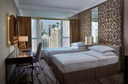 香港香港湾仔帝盛酒店的酒店客房设有两张床、一张书桌和一个窗户。