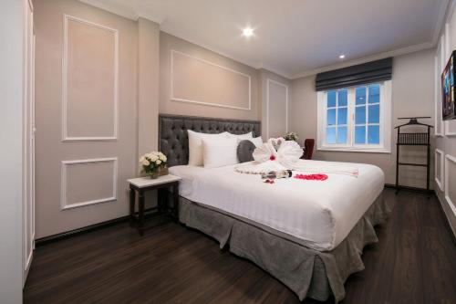 河内Flora Centre Hotel & Spa的一间卧室配有一张白色大床,床上有鲜花
