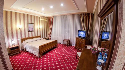 卡拉甘达Reikartz Dostar Karaganda的酒店客房,配有床和电视
