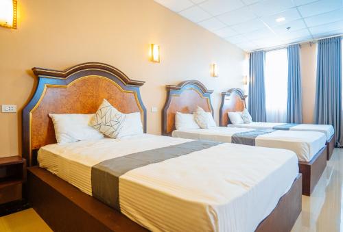 圣何塞RedDoorz Plus @ Hotel Platinum Occidental Mindoro的酒店客房,配有两张带白色床单的床